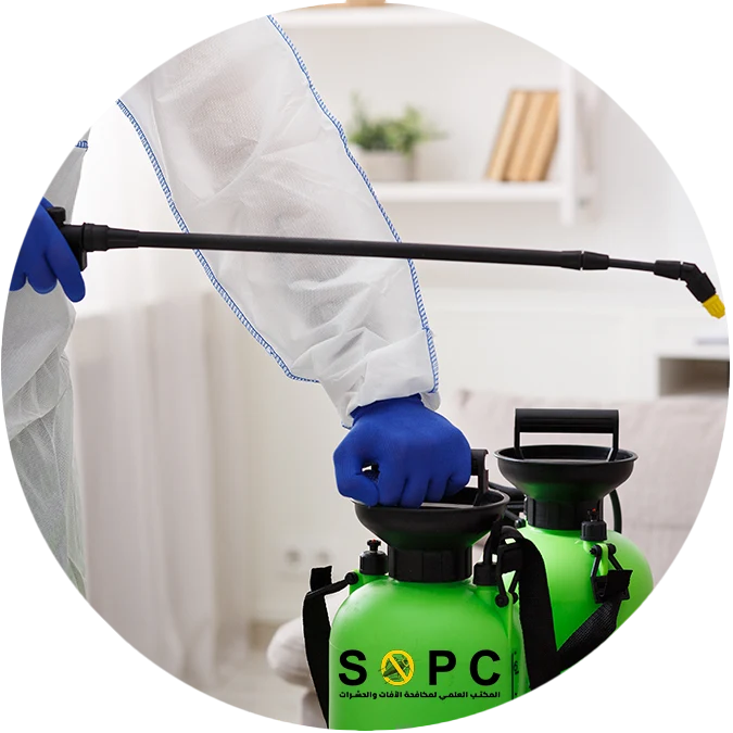 الموظف يرتدي بدلة واقية من المواد الخطرة ويحمل جهاز رش يحمل علامة SOPC التجارية